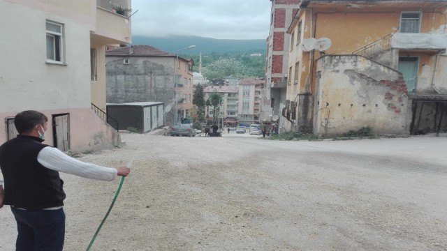 Tozdan bunalan esnaf, çareyi yolu sulamakta buldu